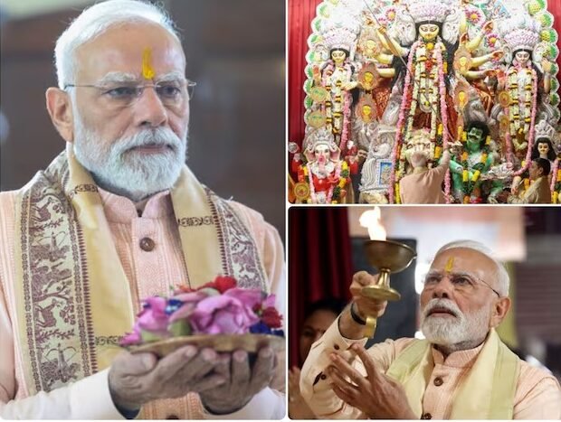 प्रधानमंत्री नरेंद्र मोदी दिल्ली के सीआर पार्क दुर्गा पूजा पंडाल में मां दुर्गा की आरती करते हुए, पीछे सजीव मूर्ति और भक्तों की भीड़।