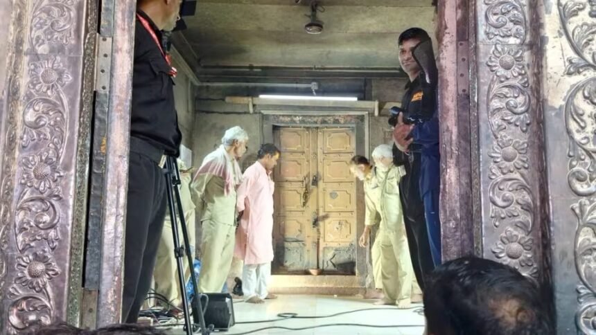 बांके बिहारी मंदिर के खजाने की संदूकें खोलते समय की तस्वीर। एक पुराना लकड़ी का संदूक खुला हुआ दिखाई दे रहा है, जिसमें पीतल के बर्तन, कुछ लकड़ी के सामान और खाली आभूषणों के बॉक्स रखे हैं।