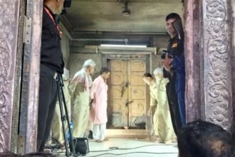 बांके बिहारी मंदिर के खजाने की संदूकें खोलते समय की तस्वीर। एक पुराना लकड़ी का संदूक खुला हुआ दिखाई दे रहा है, जिसमें पीतल के बर्तन, कुछ लकड़ी के सामान और खाली आभूषणों के बॉक्स रखे हैं।