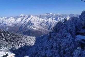 उत्तराखंड के पहाड़ी और मैदानी इलाकों में चटख धूप के बीच हल्की ठंड महसूस होती स्थिति, लोग सुबह में हल्की गर्मी का आनंद लेते हुए।