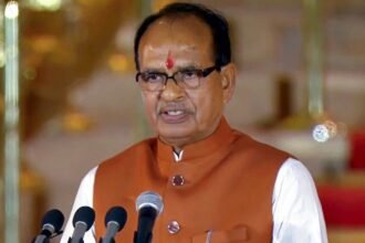 केंद्रीय कृषि मंत्री शिवराज सिंह चौहान ओडिशा में मंडिया दिवस कार्यक्रम में किसानों को संबोधित करते हुए। मंच पर अतिथि, मिलेट्स से जुड़े बैनर और उपस्थित किसान दिखाई दे रहे हैं।