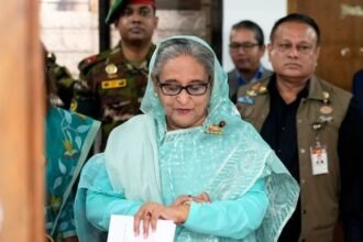 भारत में मौजूद बांग्लादेश की पूर्व प्रधानमंत्री शेख हसीना को बांग्लादेश की अंतरराष्ट्रीय अदालत द्वारा विद्रोह और मानवता विरोधी अपराधों में दोषी ठहराकर मौत की सजा सुनाए जाने से जुड़े समाचार की तस्वीर। इसमें अंतरराष्ट्रीय कानूनी प्रक्रिया और इंटरपोल नोटिस का संदर्भ।