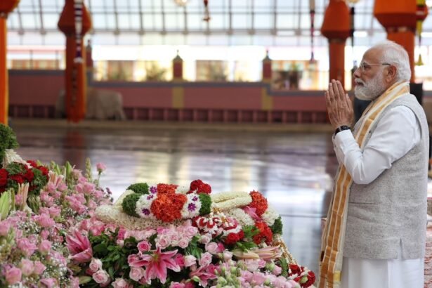 प्रधानमंत्री नरेंद्र मोदी सत्य साई बाबा मंदिर में पुष्पांजलि अर्पित करते हुए