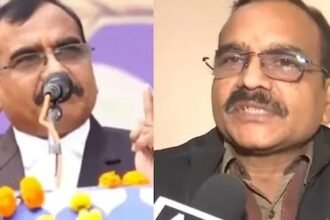 मध्य प्रदेश के IAS अधिकारी संतोष वर्मा माइक पर बोलते हुए, उनके पीछे लोग बैठे हुए हैं।