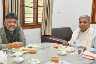 सिद्धारमैया और डीके शिवकुमार एक टेबल पर बैठकर बातचीत करते हुए ब्रेकफास्ट मीटिंग में शामिल हैं।