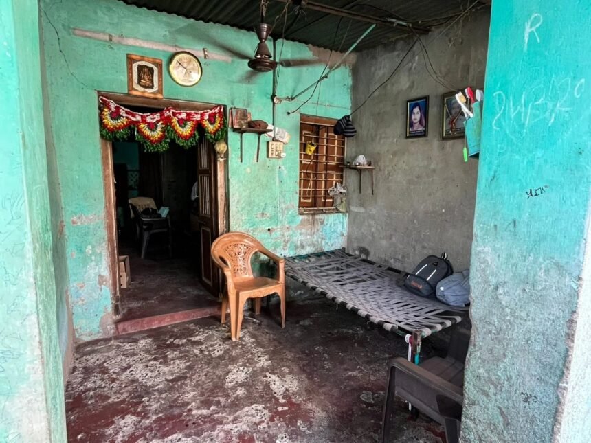 रैपिडो बाइक पर एक पुलिस अधिकारी मनी लॉन्ड्रिंग और ऑनलाइन सट्टेबाजी की जाँच के प्रतीक के रूप में बैंक दस्तावेजों की जाँच कर रहा है।