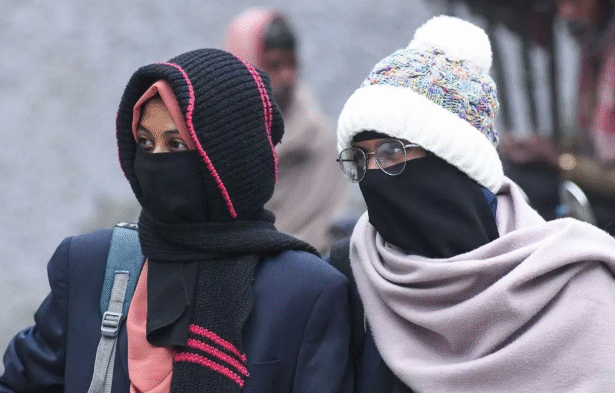 बिहार में घना कोहरा और कोल्ड डे के दौरान सड़क पर कम दृश्यता के बीच लोग ठंड से बचने के लिए गर्म कपड़े पहने हुए