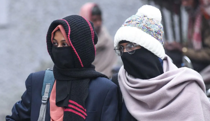 बिहार में घना कोहरा और कोल्ड डे के दौरान सड़क पर कम दृश्यता के बीच लोग ठंड से बचने के लिए गर्म कपड़े पहने हुए