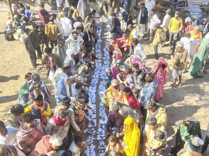 मध्य प्रदेश के राजगढ़ जिले में एक सहकारी विपणन समिति कार्यालय के दरवाजे पर किसान अपने आधार कार्ड और जमीन के दस्तावेज़ धागे से बांधकर यूरिया के लिए इंतज़ार कर रहे हैं।