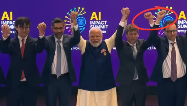 भारत मंडपम में आयोजित AI समिट के मंच पर पीएम नरेंद्र मोदी की मौजूदगी में सैम ऑल्टमैन और डारियो अमोदेई हाथ मिलाने से बचते हुए मुट्ठियां उठाते हुए दिखाई दे रहे हैं