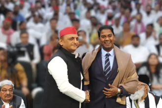 अखिलेश यादव और राजरतन अंबेडकर एक साथ हाथ उठाकर एकजुटता दिखाते हुए, बैकग्राउंड में 'समाजवादी पार्टी' और 'बाबा साहेब' के पोस्टर।