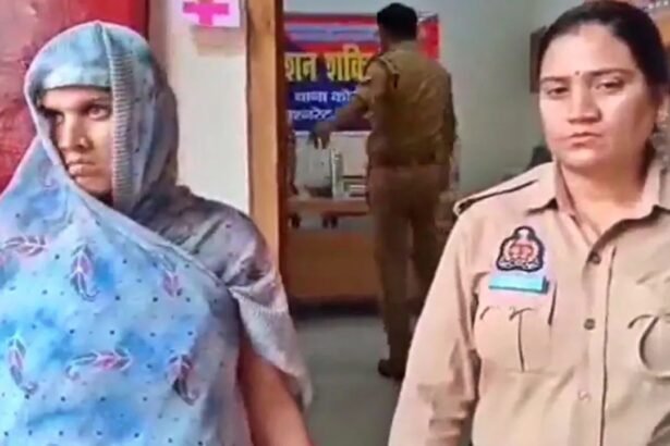 कानपुर हत्याकांड में आरोपी महिला को पुलिस हिरासत में ले जाती हुई, साथ में एक महिला पुलिसकर्मी नजर आ रही है।