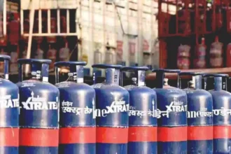 एक नीले रंग का कमर्शियल एलपीजी सिलेंडर और बगल में बढ़ती कीमतों का ग्राफ दिखाता हुआ एक सांकेतिक चित्र.