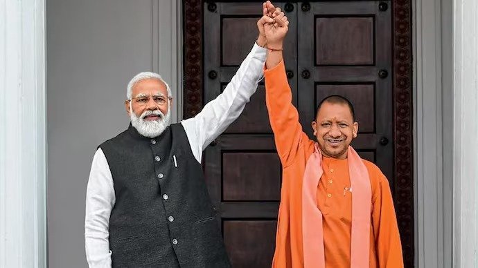 प्रधानमंत्री नरेंद्र मोदी और मुख्यमंत्री योगी आदित्यनाथ की तस्वीर के साथ उत्तर प्रदेश में विकास परियोजनाओं, राम मंदिर, जेवर एयरपोर्ट, गंगा एक्सप्रेसवे और महाकुंभ की झलक दिखाती हुई ग्राफिक