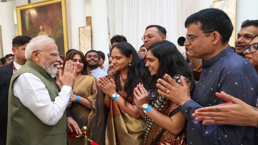 पेरिस में प्रधानमंत्री नरेंद्र मोदी का भारतीय समुदाय द्वारा गर्मजोशी से स्वागत करते हुए दृश्य, लोग तिरंगा लहराते हुए और पीएम मोदी से मुलाकात करते हुए दिखाई दे रहे हैं